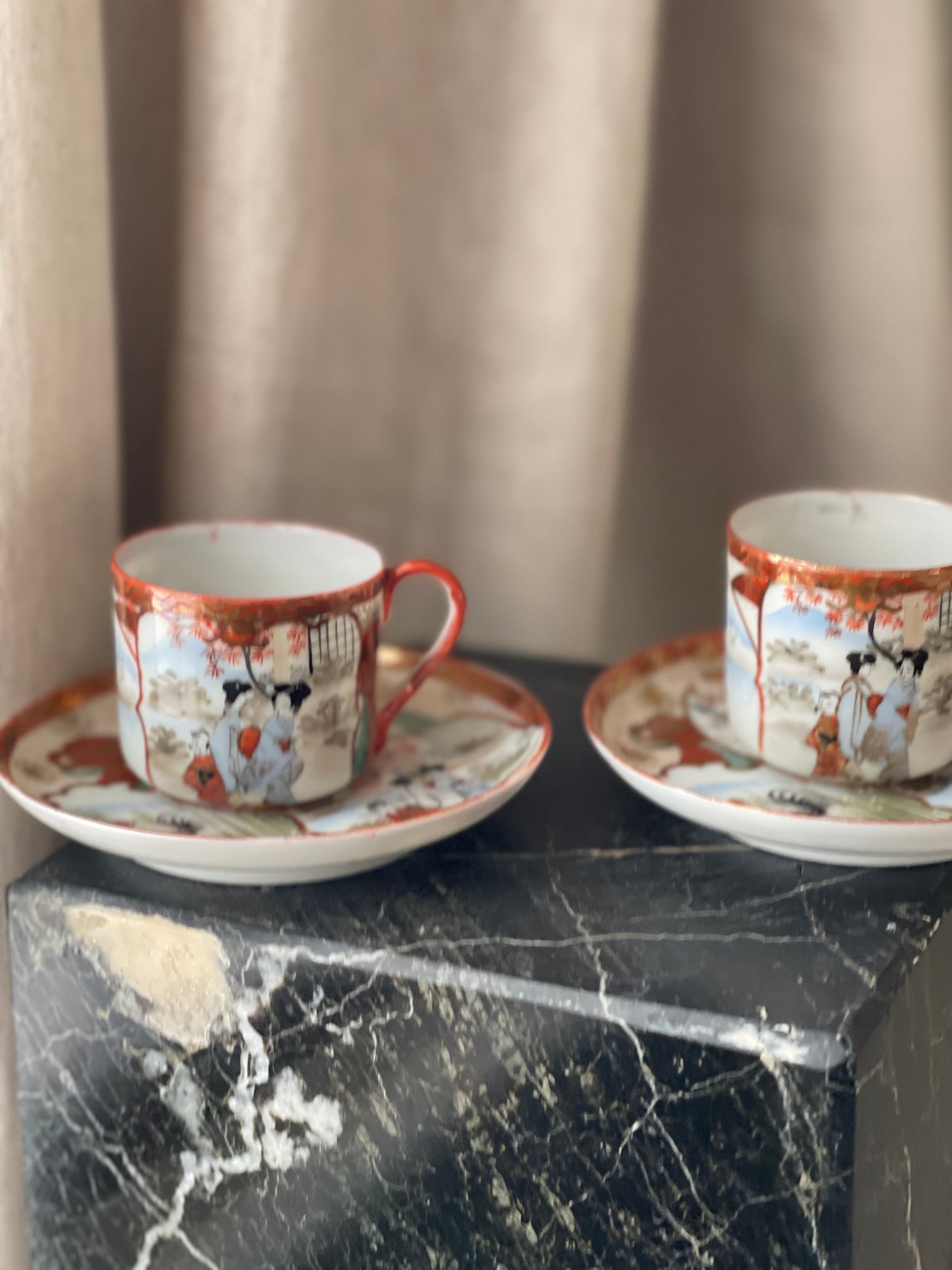 A pair of red Japanese espresso cups and saucers